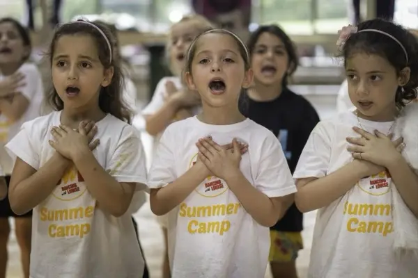 Three girls singing at camp